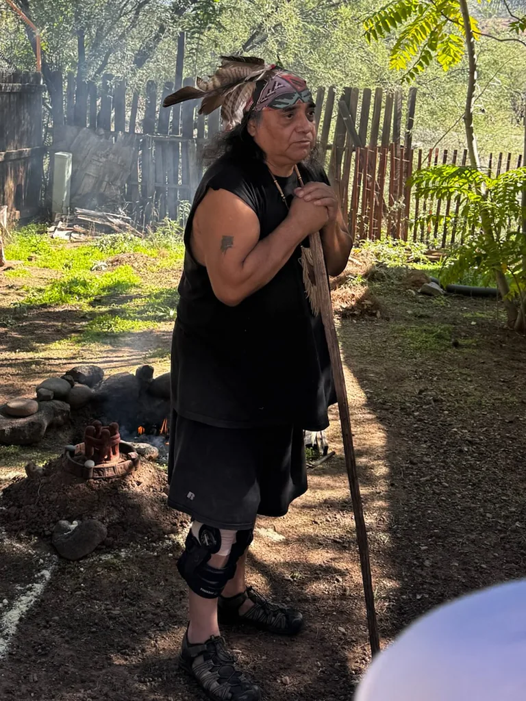M.H. Black Wolf standing beside the ceremonial fire