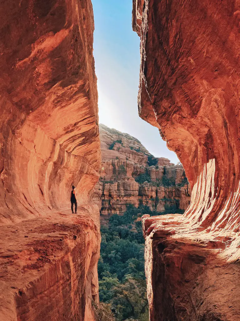 A walker dwarfed by the canyon walls at Boynton Canyon